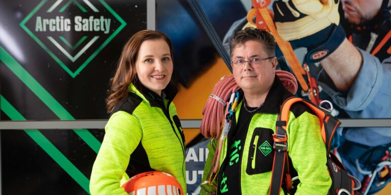 Arctic safetyn yrittäjät Hanne Nurmi ja Mika Korpiaho pukeutuneina yrityksensä myymiin keltaisiin työvaatteisiin.